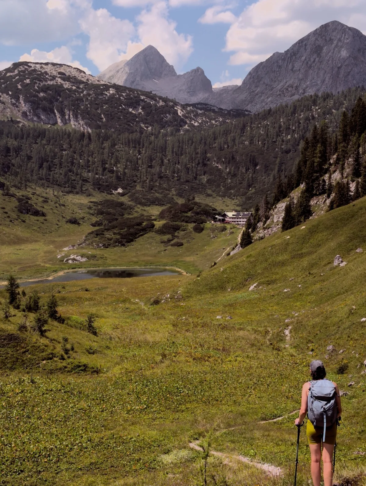 A hiker approaching a green valley and mountain hut in the Steinernes Meer photographed with the Steine film look