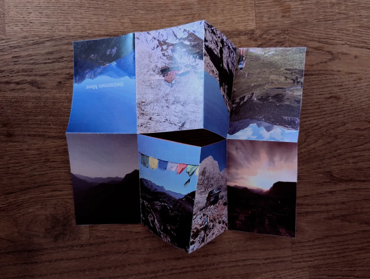 An unfolded Steinernes Meer photo zine on a wooden table.